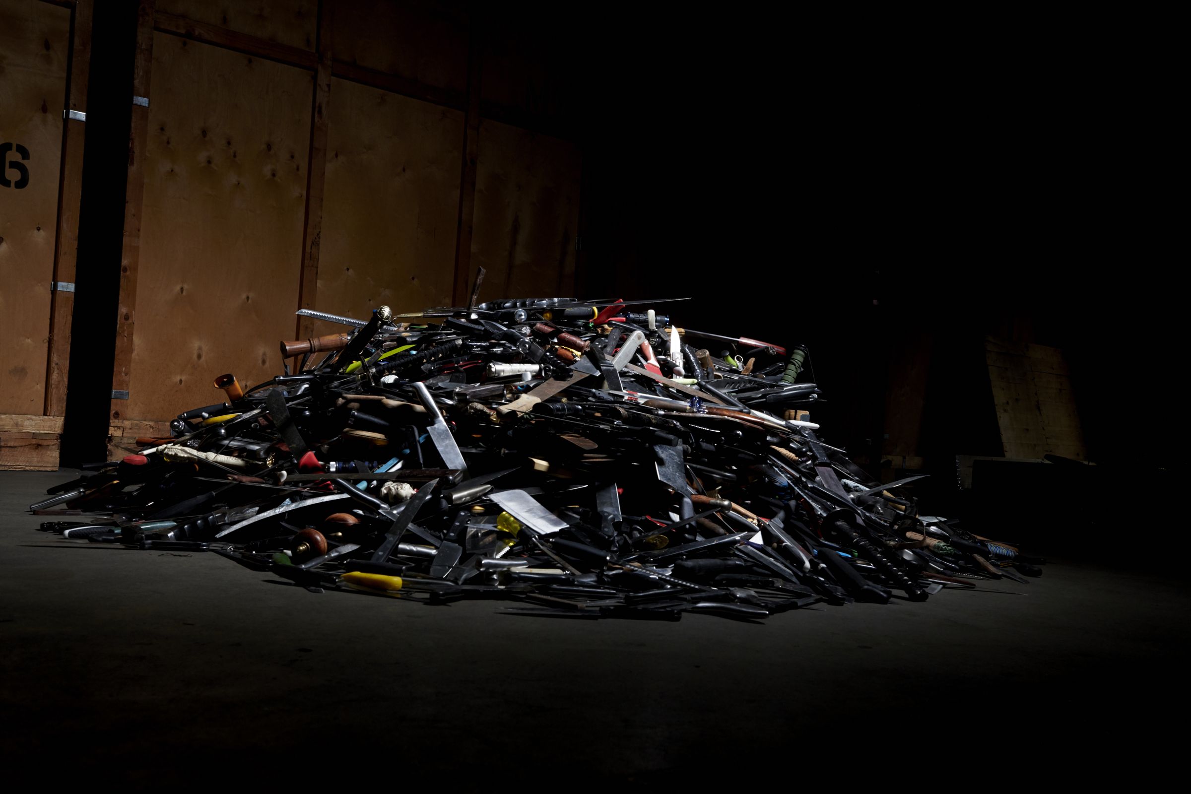 A pile of collected knives in the warehouse, waiting to be melted down