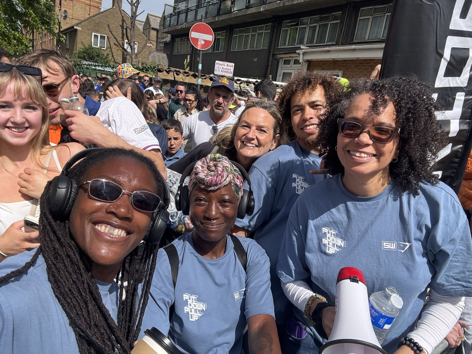 The Steel Warriors cheer crew on the London Marathon route, in team T-shirts with a megaphone