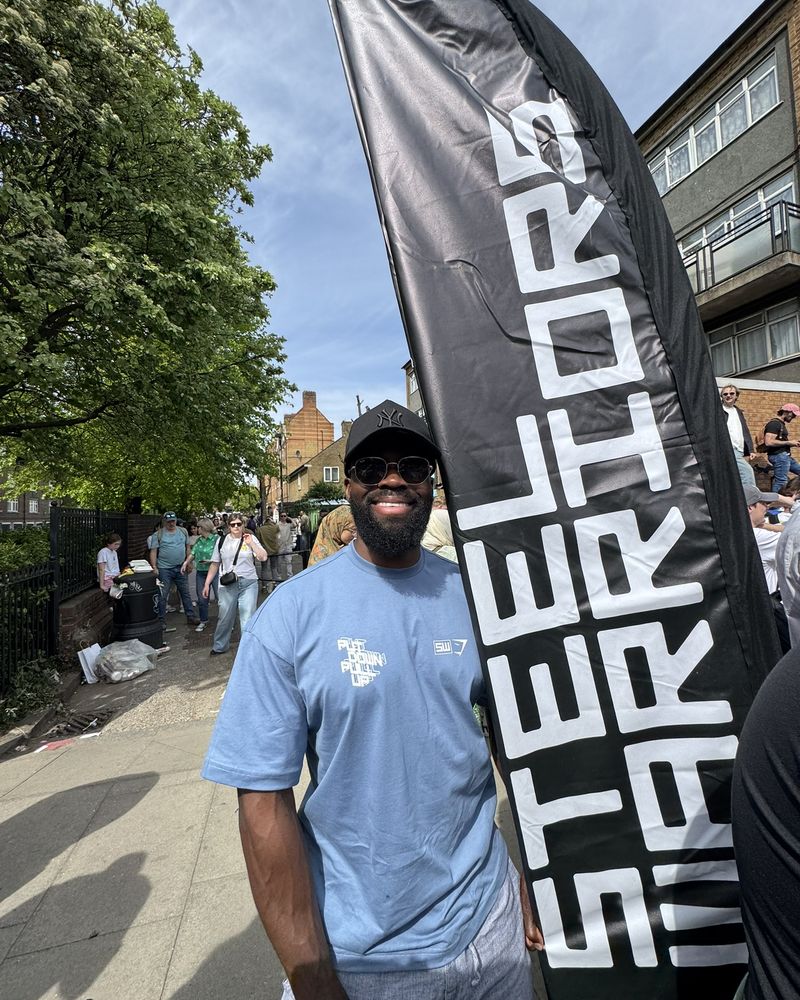A supporter in a Steel Warriors T-shirt next to our flag on the marathon route