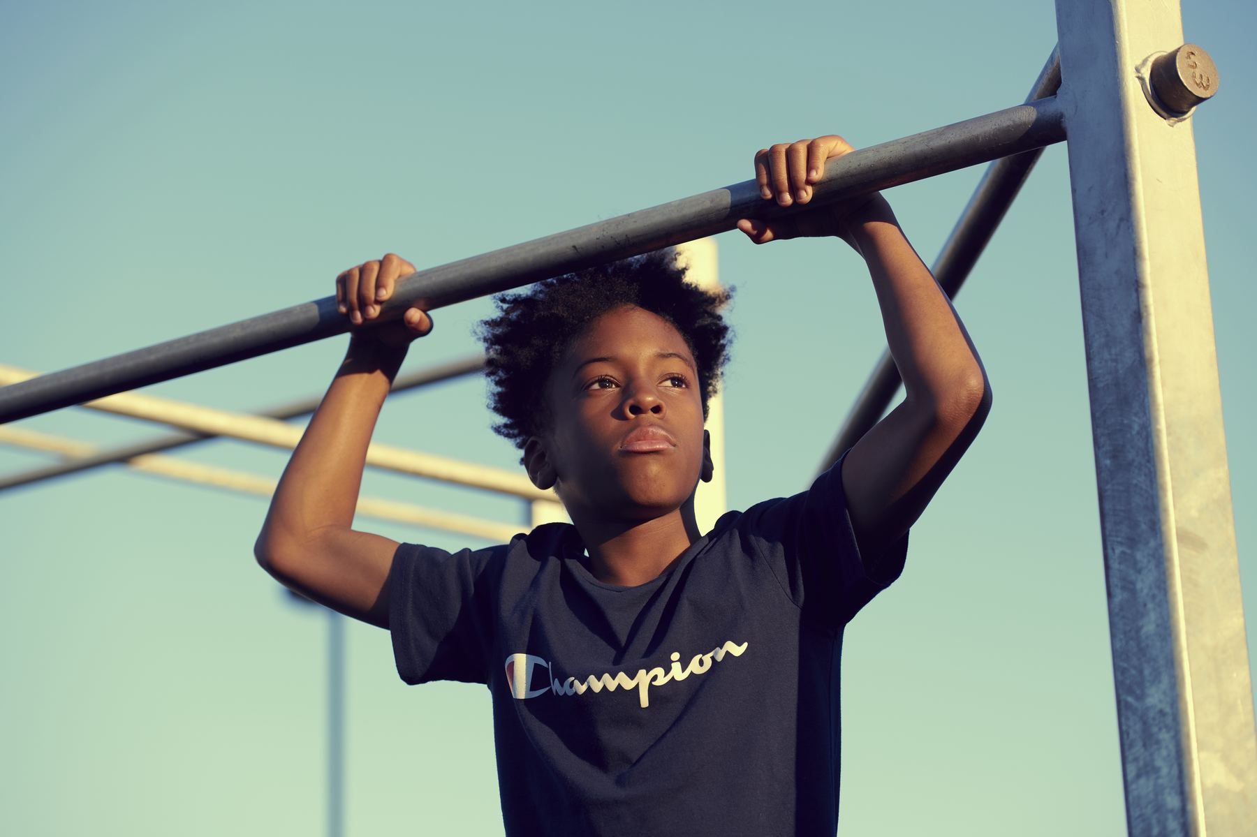 A young person doing a pull-up at a Steel Warriors gym