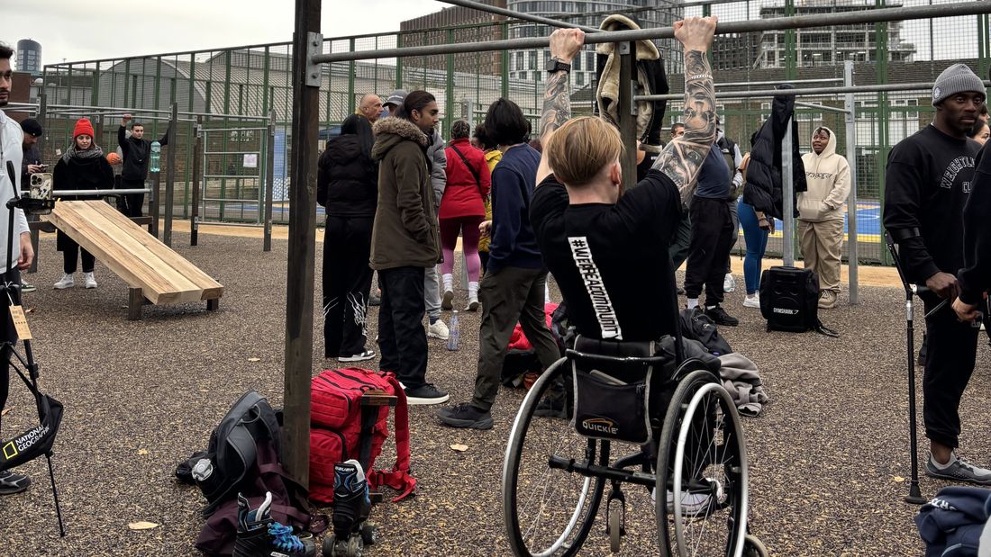 A wheelchair user doing a pull-up on the bars at an inclusive session at Carpenters Estate
