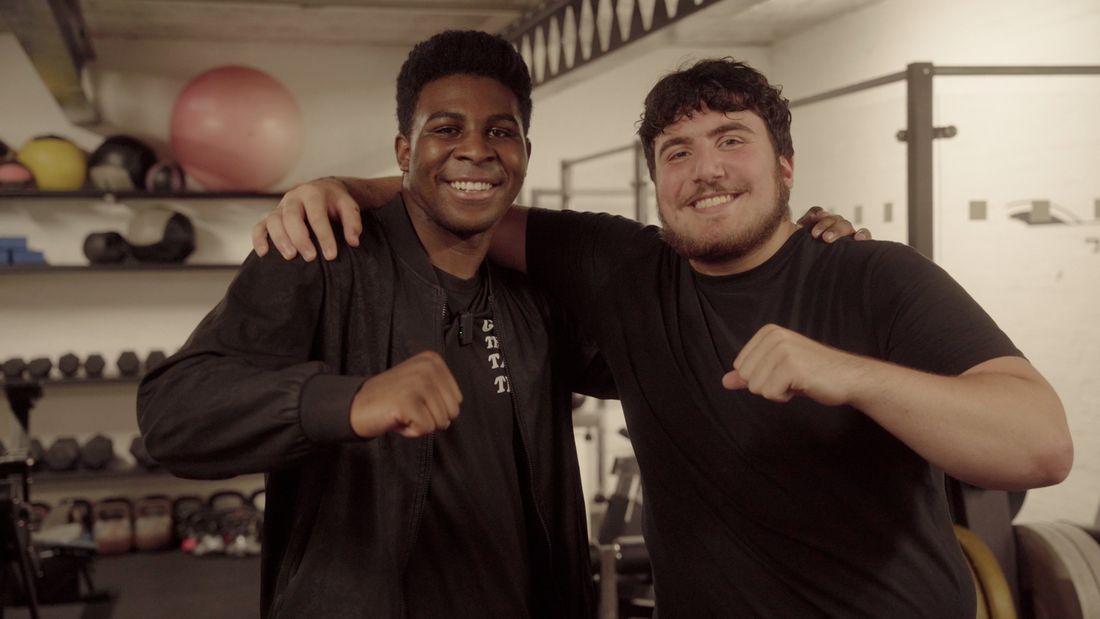 Two young people smiling together in the gym