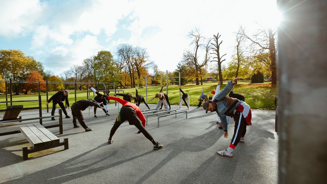 A group warming up together on the bars at Ruskin Park