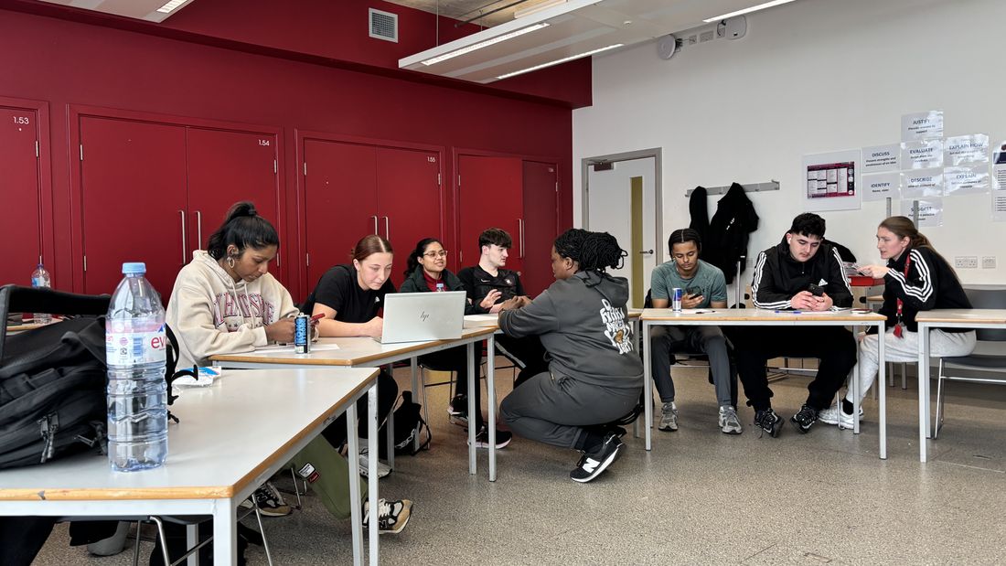 Young people working together at tables in a classroom session