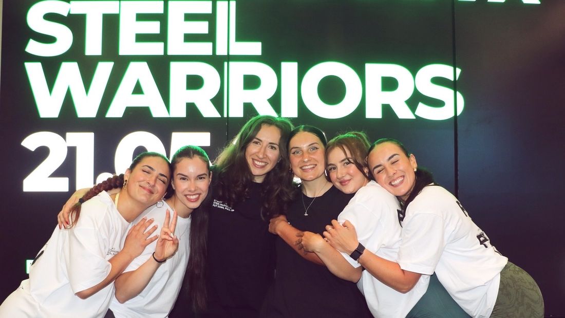 Women and girls hugging and smiling at a Steel Warriors event